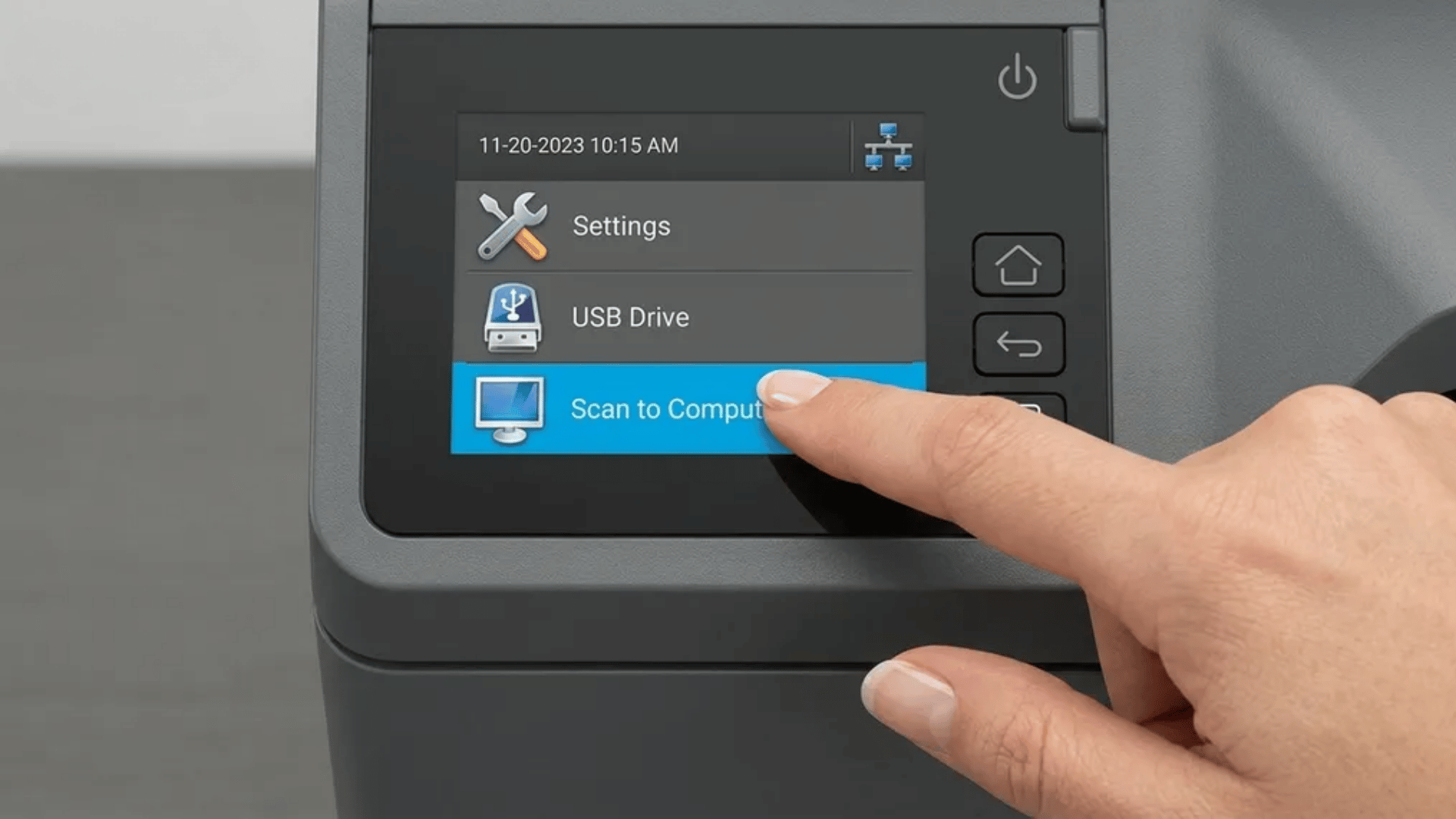 Printer touchscreen showing menu with Settings, USB Drive, and Scan to Computer option highlighted while a finger taps on Scan to Computer.