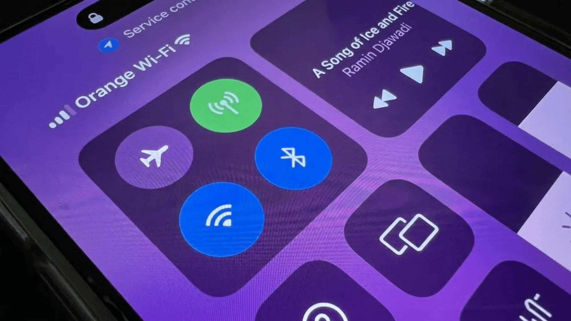 iPhone Control Center showing Wi-Fi, Bluetooth, Airplane Mode, and AirDrop toggle tiles on a purple background interface.